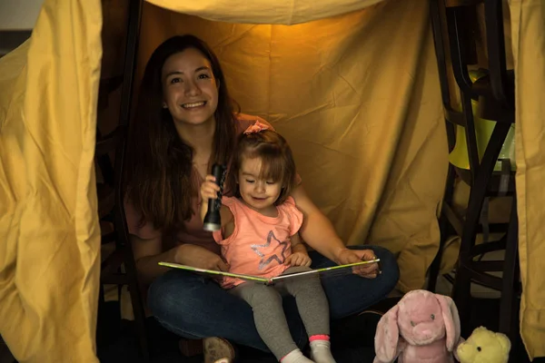 Mother reading story inside fort — Stock Photo, Image