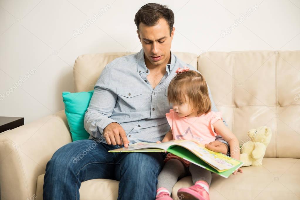 Girl reading book with father