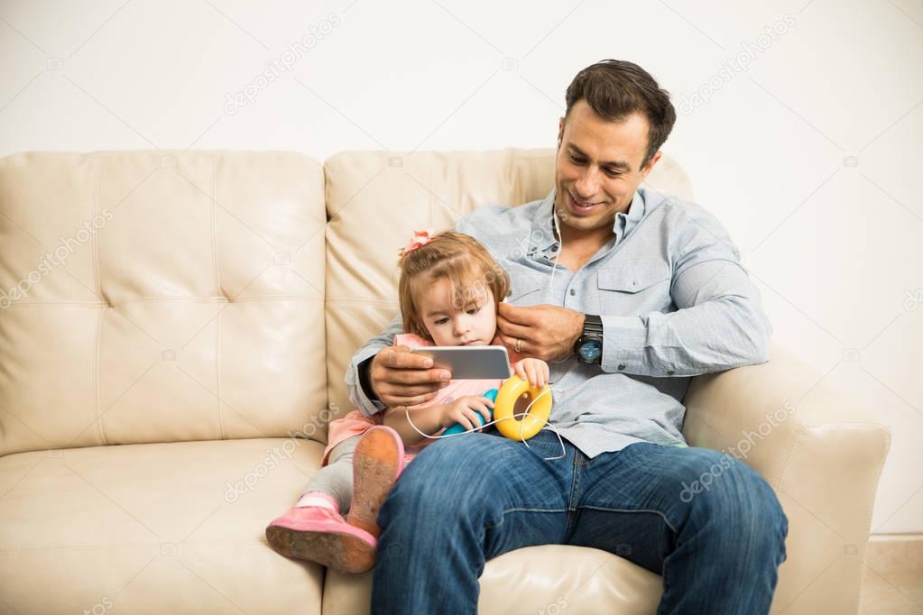 Father and daughter listening music 