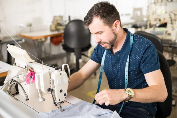 Sastre guapo usando una máquina de coser — Foto de Stock