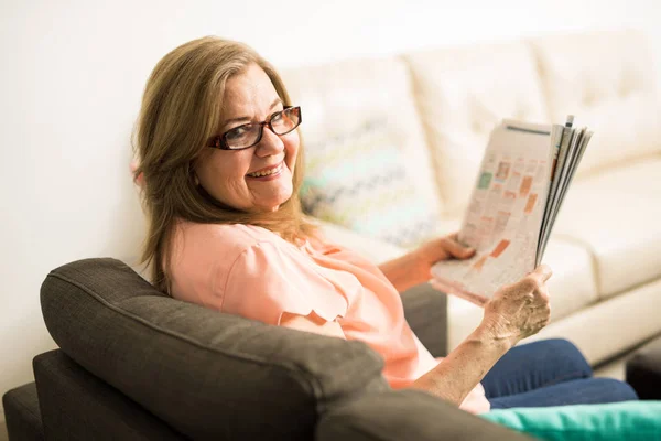 Granny wtih newspaper between hands — Stock Photo, Image