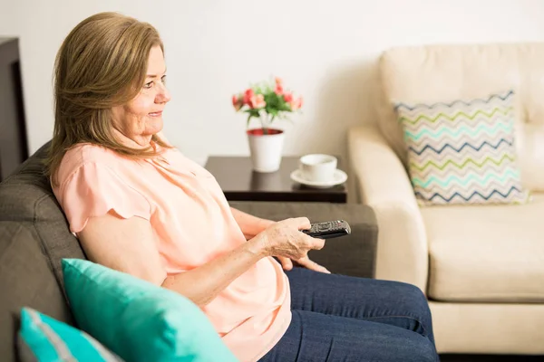 Old woman pushing remote buttons