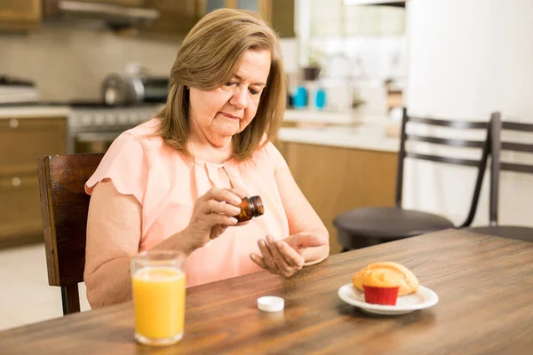 Nonna che prende farmaci con la colazione — Foto Stock