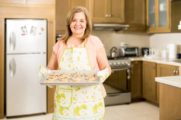 Mujer mostrando galletas recién horneadas — Foto de Stock