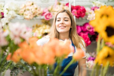 Genç bir işçi bir mağaza çiçek stok kontrol