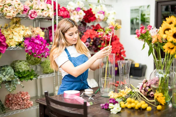 Жінка кладе квіти всередину вази — стокове фото
