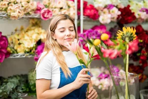 Çiçek koklayan genç bir kadın — Stok fotoğraf