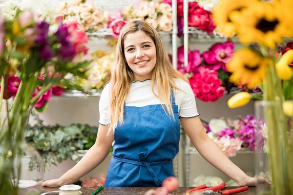Жіночий флорист стоїть у квітковому магазині — стокове фото