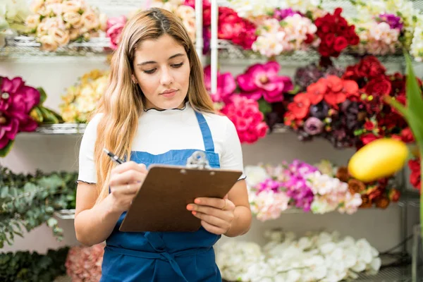 Florist working on a flower inventory — Stock Photo, Image