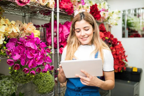 Fleuriste féminine utilisant une tablette pour le travail — Photo