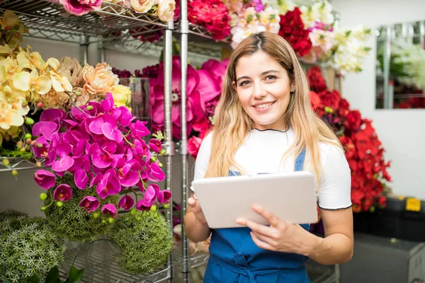 Працівник квіткового магазину використовує планшет — стокове фото