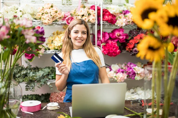 Florist holding ett kreditkort i hennes blomsteraffär — Stockfoto