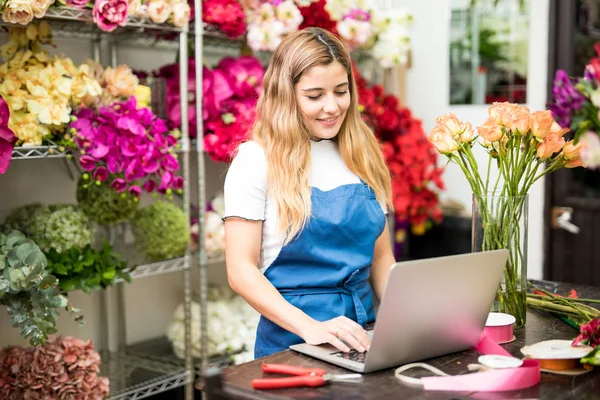 Kvinnliga florist skriva på hennes dator — Stockfoto
