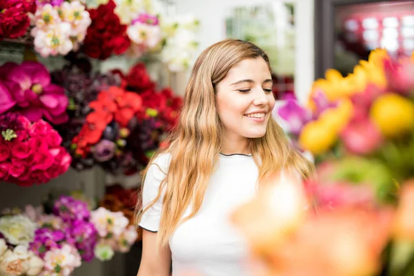 Mladá žena obklopená květinami — Stock fotografie