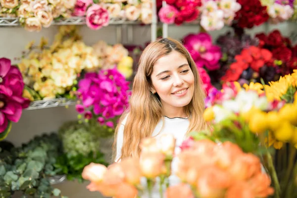 Pretty woman surrounded by flowers — Stock Photo, Image
