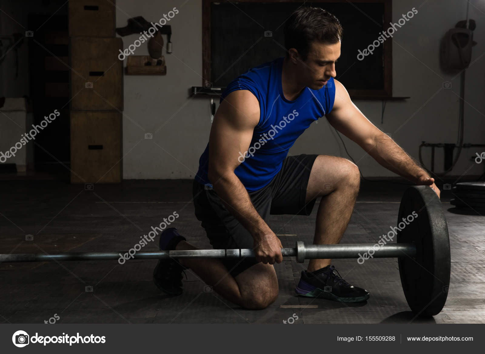 Adding weights to a barbell Stock Photo by ©tonodiaz 155509288
