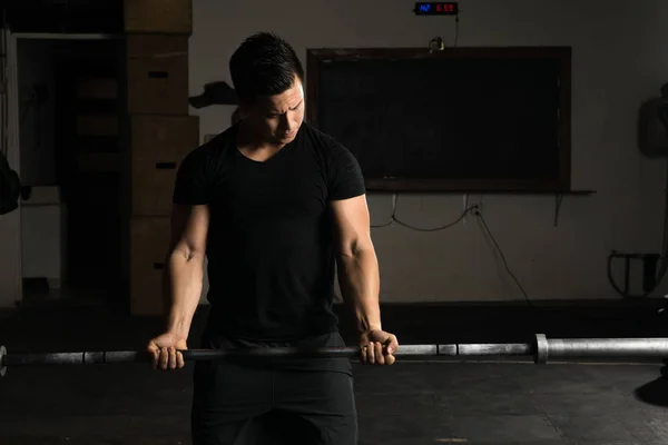 Hombre haciendo ejercicio con una barra — Foto de Stock