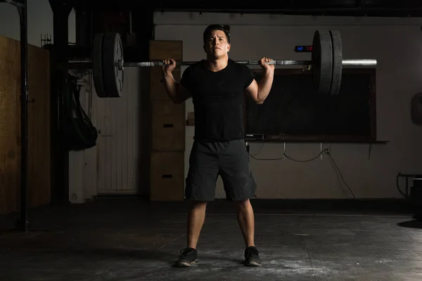 Young sportsman doing barbell squats — Stock Photo, Image