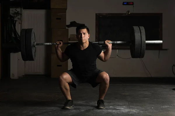 Homme fort soulevant une haltère au gymnase — Photo