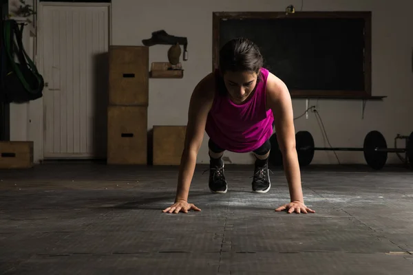 Mujer activa haciendo flexiones en un gimnasio —  Fotos de Stock