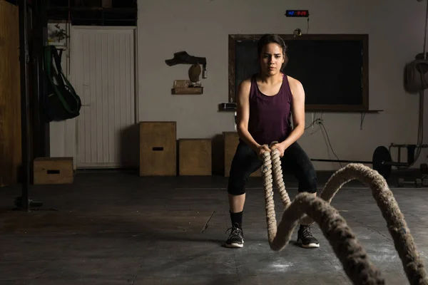 Woman using battle ropes for working out