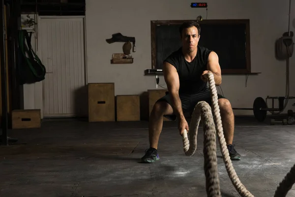 Сильный человек, тренирующийся с боевыми веревками — стоковое фото