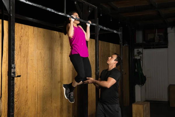 Γυναίκα λήψη βοήθειας με χρήση της pull-ups — Φωτογραφία Αρχείου