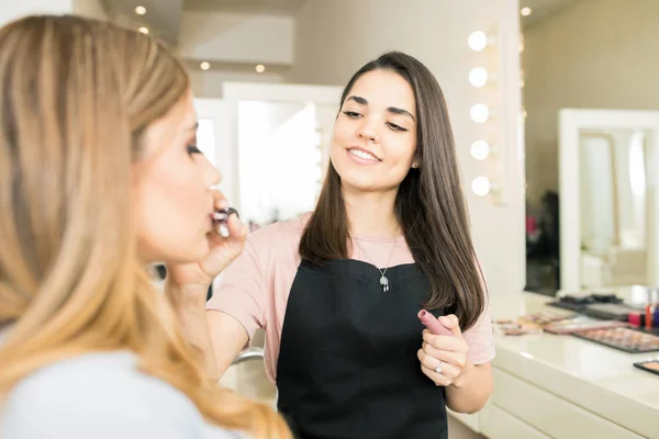 Kunstenaar zetten sommige lippenstift — Stockfoto