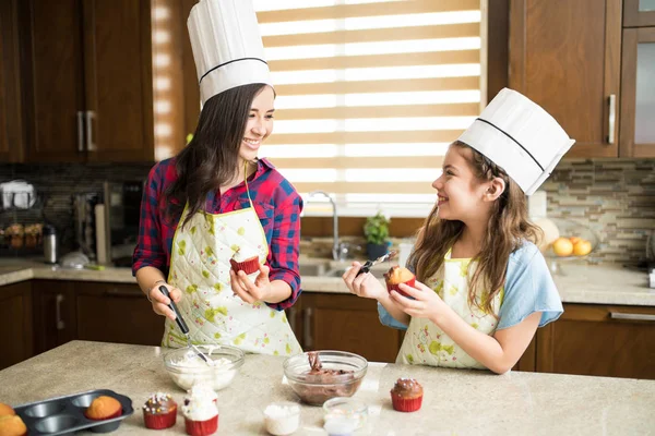 Äiti ja tytär koristelu cupcakes — kuvapankkivalokuva