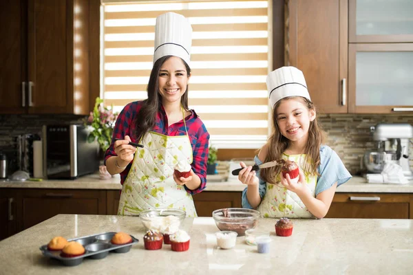 Mor och dotter dekorera muffins — Stockfoto