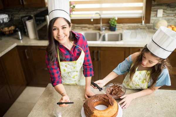 Mother and girl decorating cake — Stock Photo, Image
