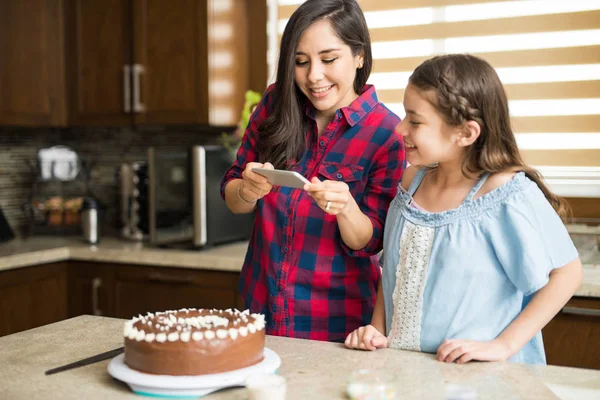 Мати і дочка фотографують торт — стокове фото