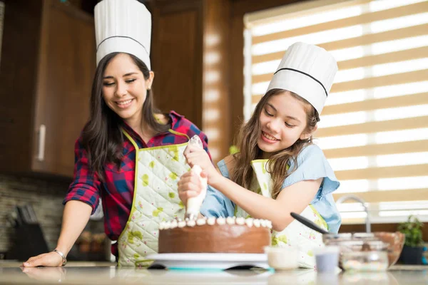 Mother and girl decorating cake — Stock Photo, Image