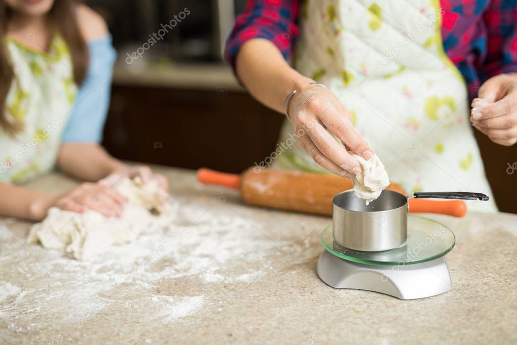 woman and daughter weighing cookie dough