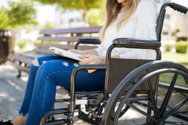 Kadın tekerlekli sandalyeye mahkum bir kitap okuma