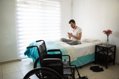 Adam telefonu kullanarak tekerlekli sandalye üzerinde