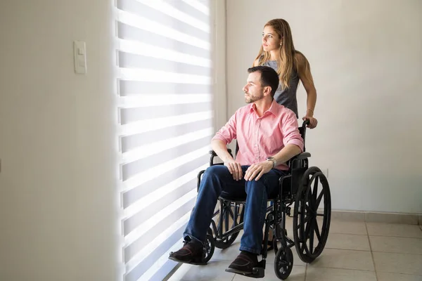 Uomo triste su una sedia a rotelle con il suo partner — Foto Stock