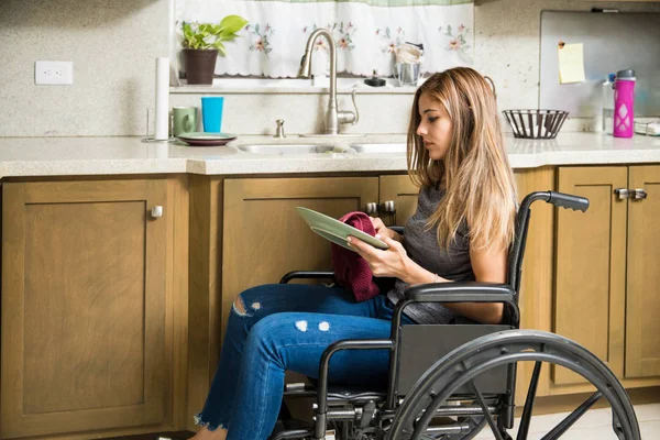 Жінка в інвалідному візку миє посуд — стокове фото