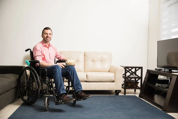 Щасливий чоловік на інвалідному візку дивитися телевізор — стокове фото