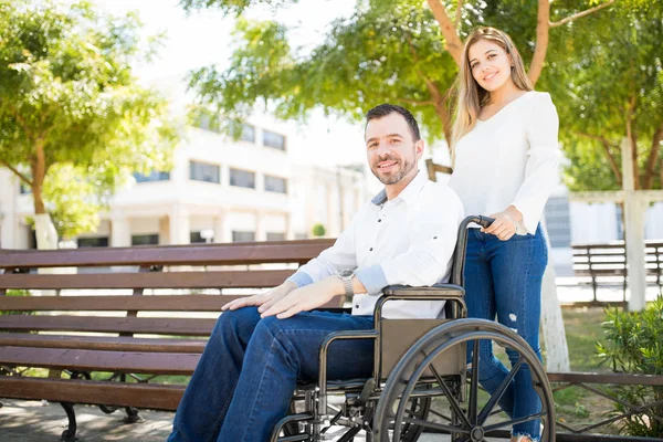Frau schiebt Mann im Rollstuhl — Stockfoto