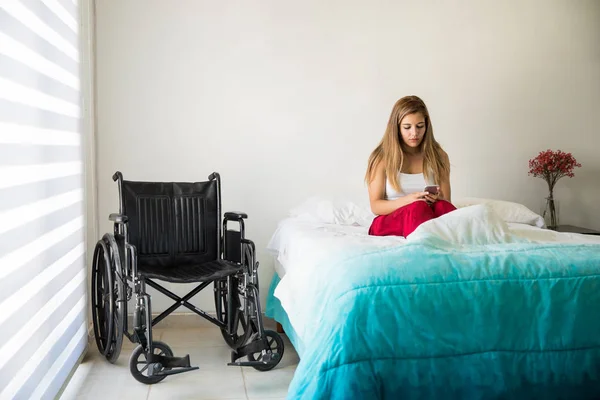 Woman in wheelchair using smartphone — Stock Photo, Image