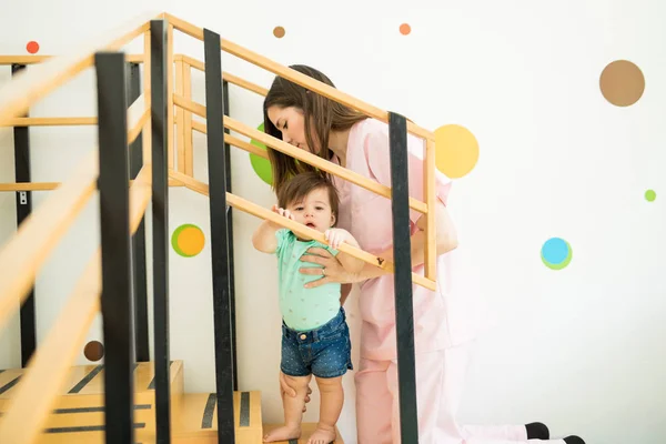 Terapeuta ayudando al bebé a subir escaleras — Foto de Stock