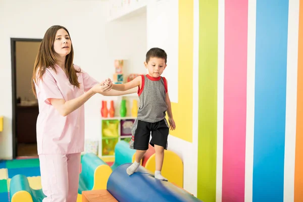 Terapeuta ayudando a un niño con equilibrio — Foto de Stock