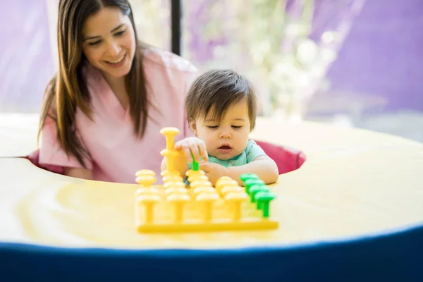 Bebé y terapeuta jugando con juguetes — Foto de Stock