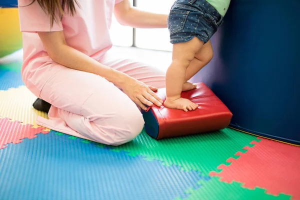 Terapeuten hjälper barnet med balans — Stockfoto