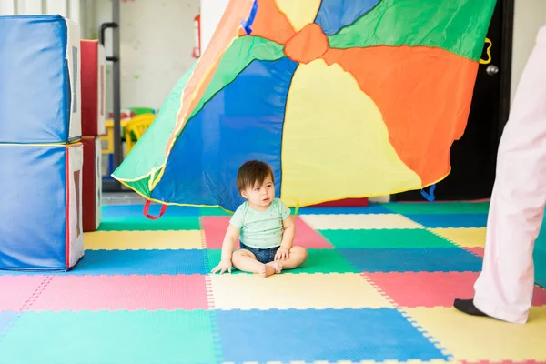 Baby looking at a colorful parachute — Stock Photo, Image