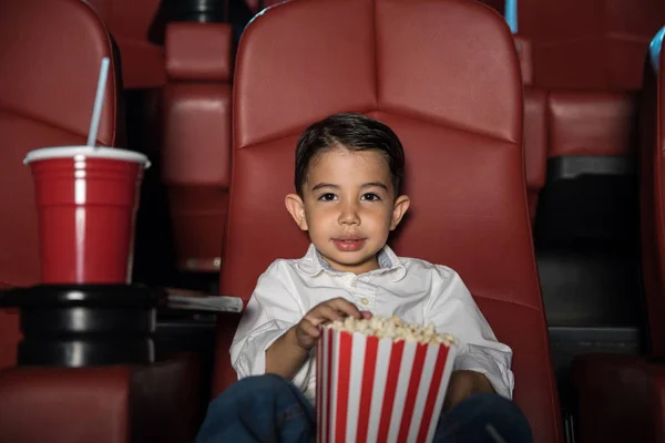 Garçon assis au cinéma manger du pop-corn — Photo