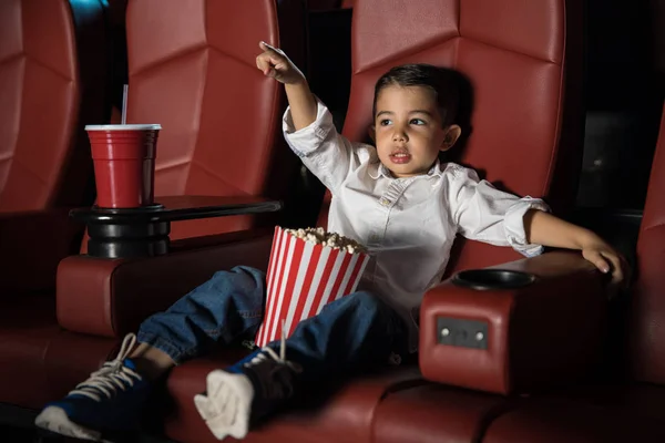Niño viendo la película en el cine y señalando el dedo — Foto de Stock