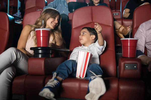 Little boy talking to mom at cinema