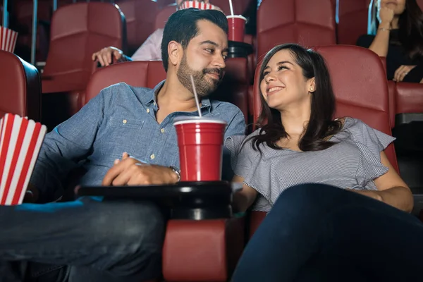 Couple smiling at each other in cinema — Stock Photo, Image